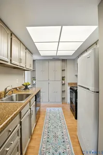 a kitchen with a sink a refrigerator and cabinets