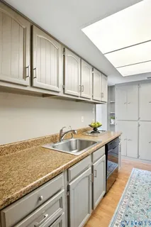 a kitchen with stainless steel appliances granite countertop a sink stove and cabinets