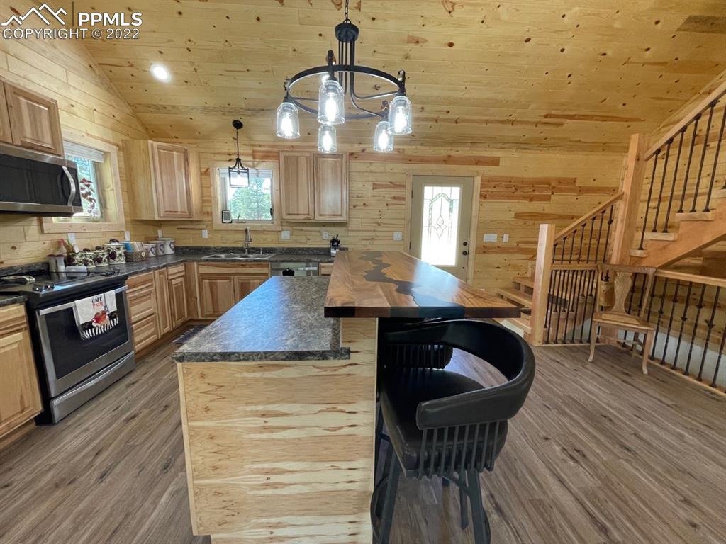 188 Keepsake Loop Westcliffe, CO 81252 - Photo 23 of 37 a kitchen with granite countertop a stove a sink and a wooden floors