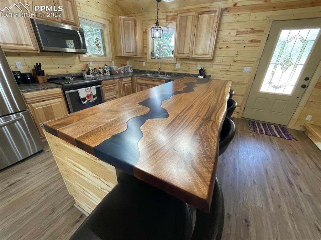 188 Keepsake Loop Westcliffe, CO 81252 - Photo 3 of 37 a kitchen with stainless steel appliances wooden floors wooden cabinets a sink and a stove