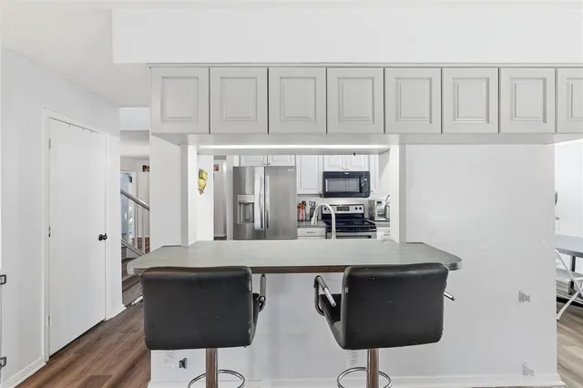 a kitchen with stainless steel appliances granite countertop a sink a stove and a wooden floors