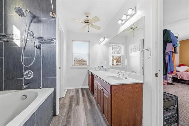 a bathroom with a bathtub sink and mirror