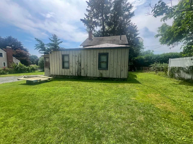 a view of backyard with potted plants and large tree