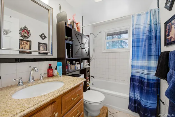 a bathroom with a granite countertop sink a toilet and a shower