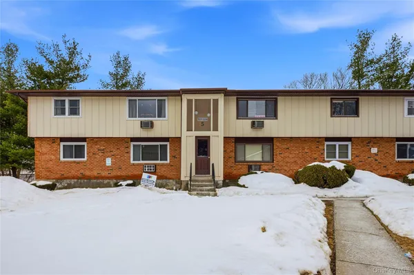 a front view of a house with cars parked