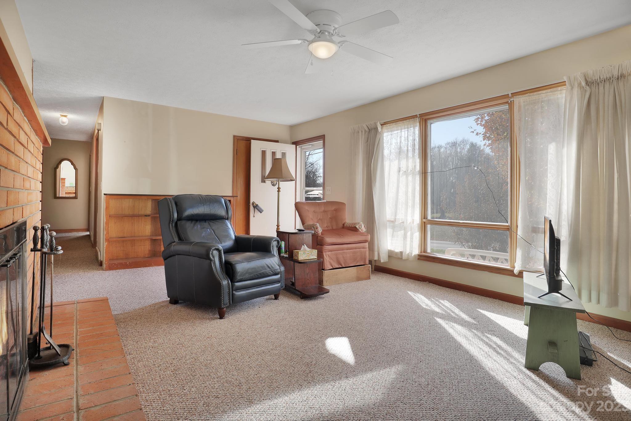 56 Thompson Cove Road, Unit 8 Clyde, NC 28721 - Photo 8 of 21 a living room with furniture and a floor to ceiling window