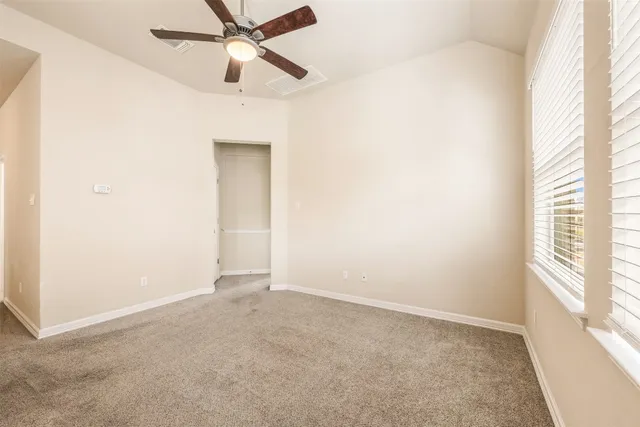an empty room with a window and a fan