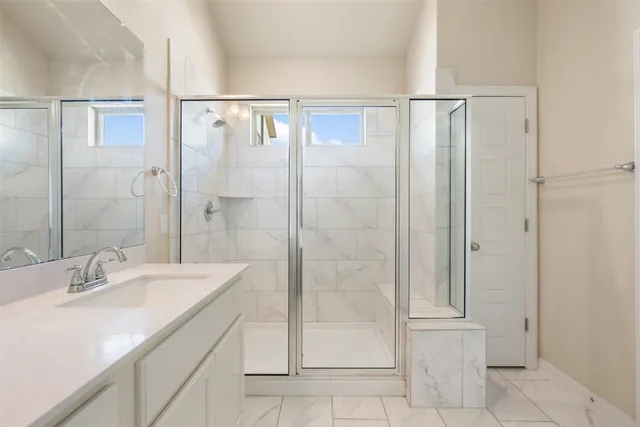 a bathroom with a shower sink and mirror