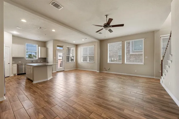 a view of an empty room with window and wooden floor