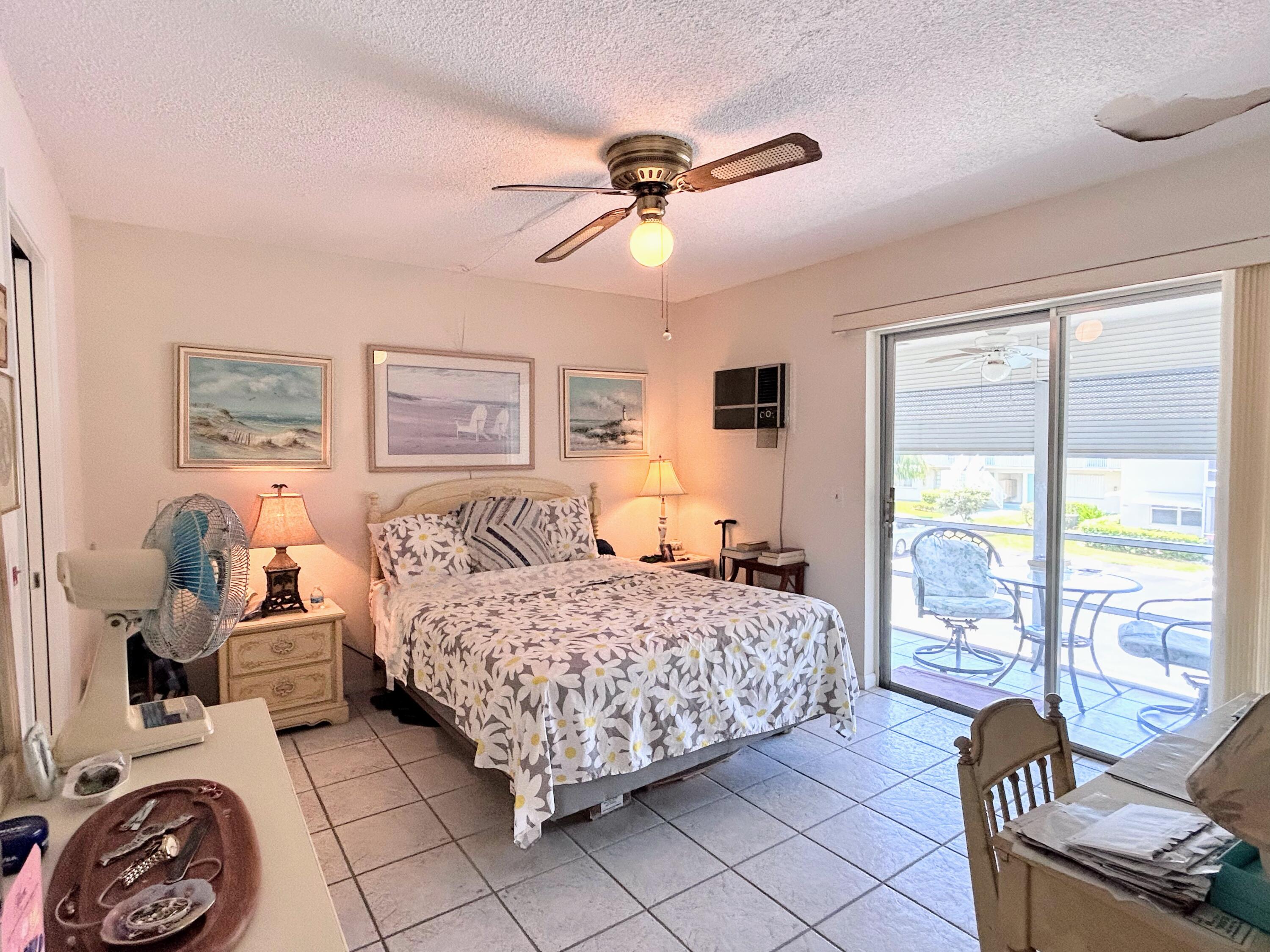 340 Horizon West, Unit 203 Boynton Beach, FL 33435 - Photo 11 of 45 a bedroom with a bed and a chandelier