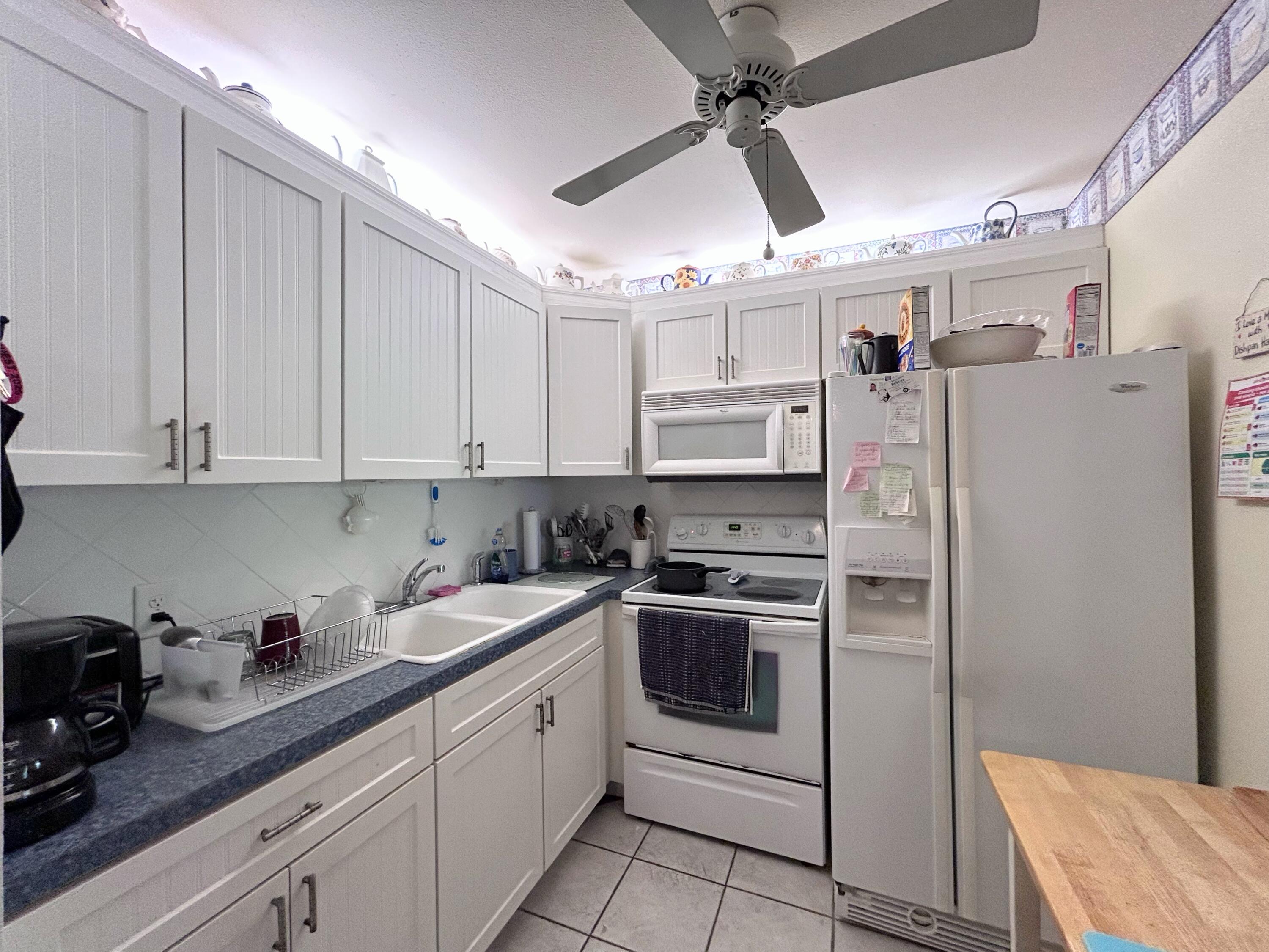 340 Horizon West, Unit 203 Boynton Beach, FL 33435 - Photo 7 of 45 a kitchen with stainless steel appliances granite countertop a refrigerator sink and stove