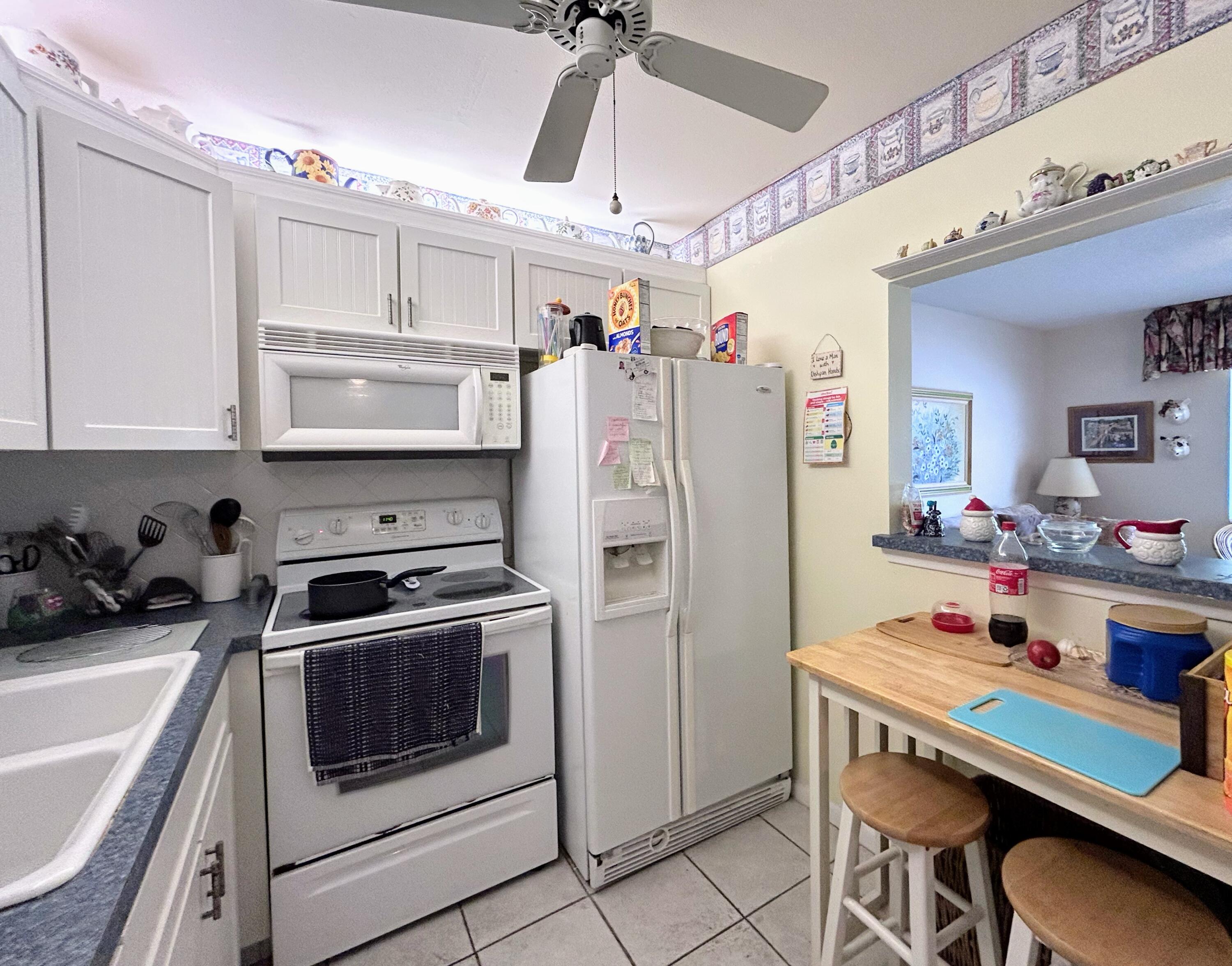 340 Horizon West, Unit 203 Boynton Beach, FL 33435 - Photo 8 of 45 a kitchen with stainless steel appliances a stove a refrigerator and cabinets