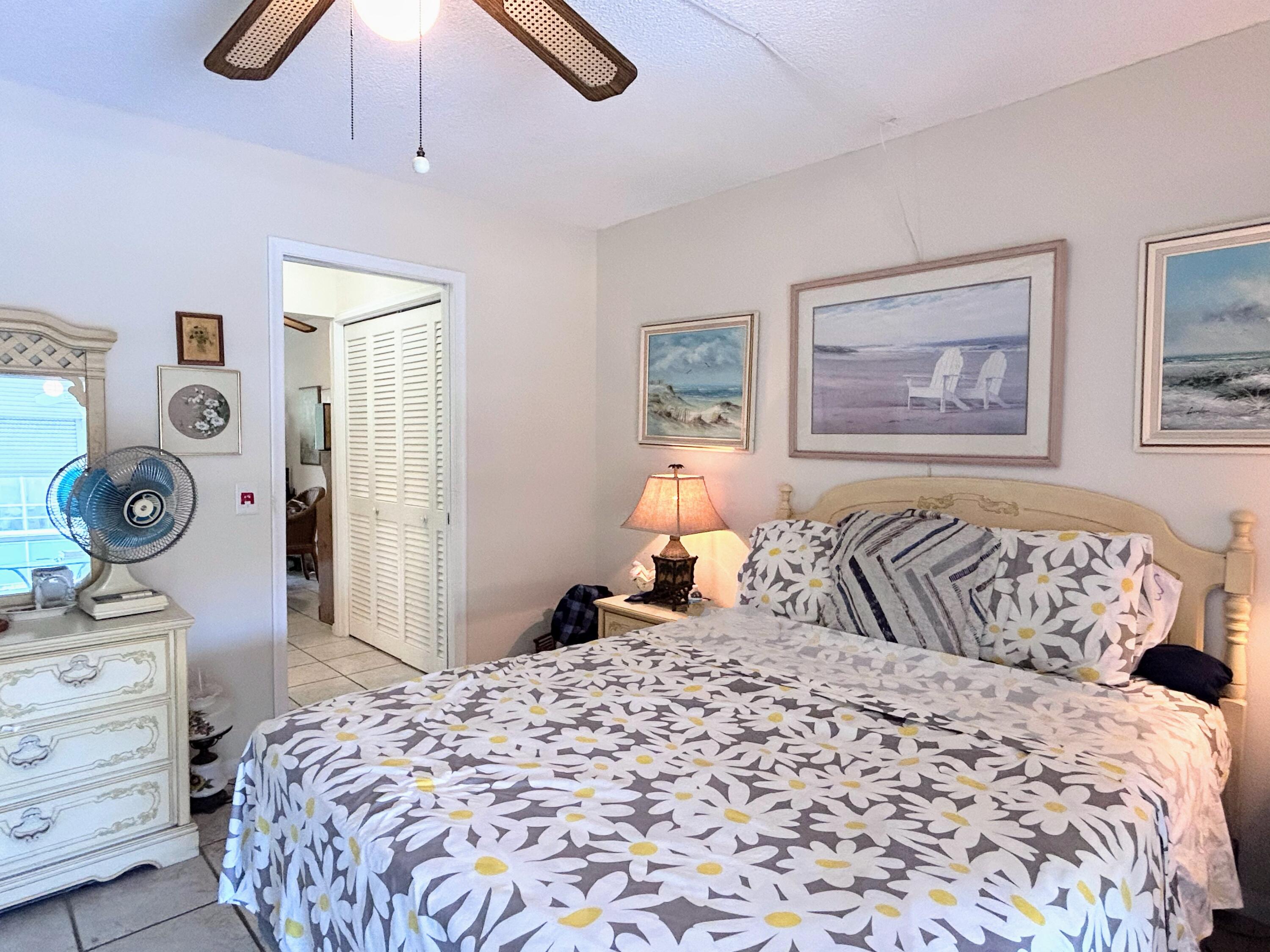 340 Horizon West, Unit 203 Boynton Beach, FL 33435 - Photo 10 of 45 a bedroom with a bed and a chandelier