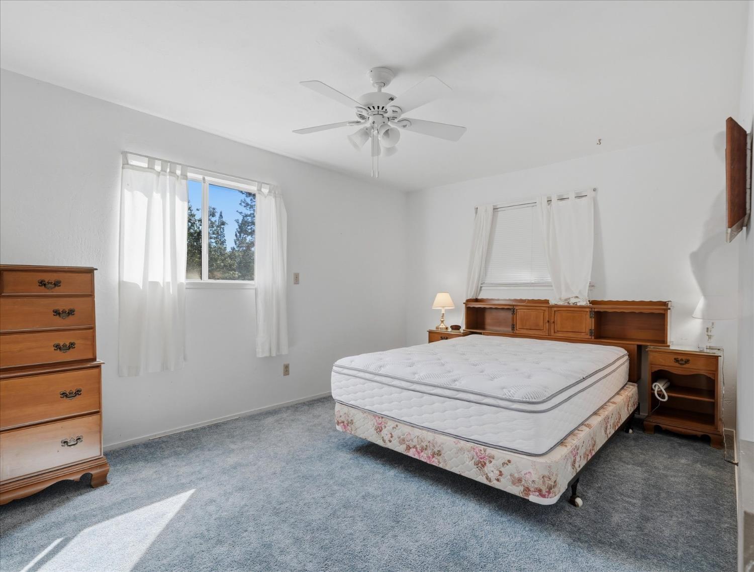 45167 Tolladay Road Oakhurst, CA 93644 - Photo 24 of 50 a bedroom with a bed and a chandelier