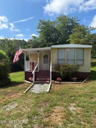 a view of a house with yard and sitting area
