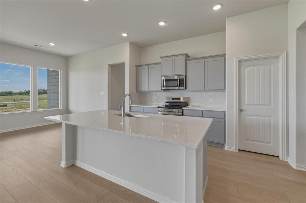 136 Hillview Trail Decatur, TX 76234 - Photo 7 of 26 Kitchen with a large central island, light wood-finish flooring, recessed lighting, and grey cabinetry