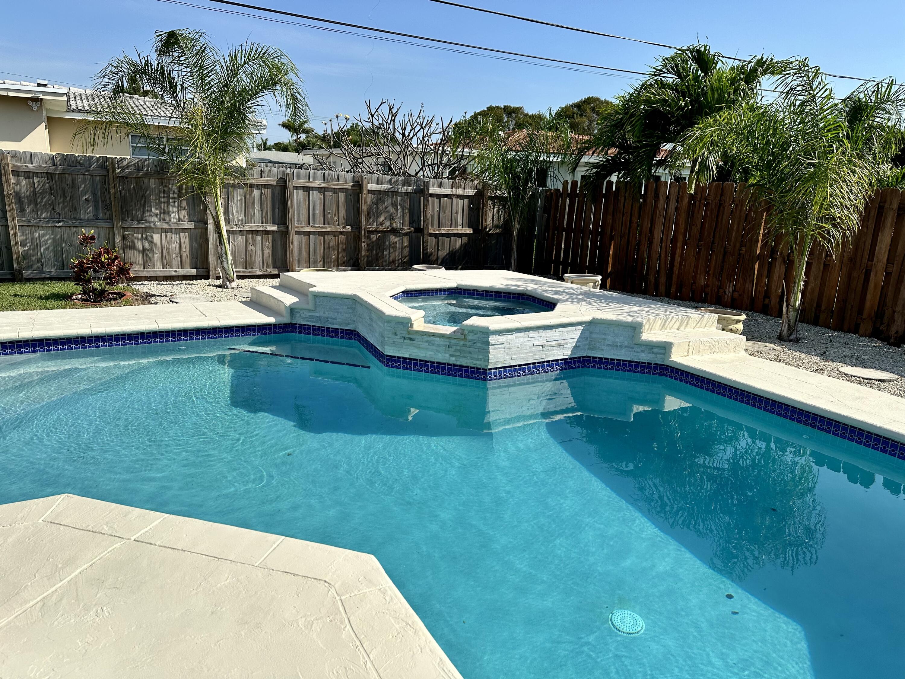 469 Northeast 30th Street Boca Raton, FL 33431 - Photo 2 of 24 a swimming pool with outdoor seating and yard
