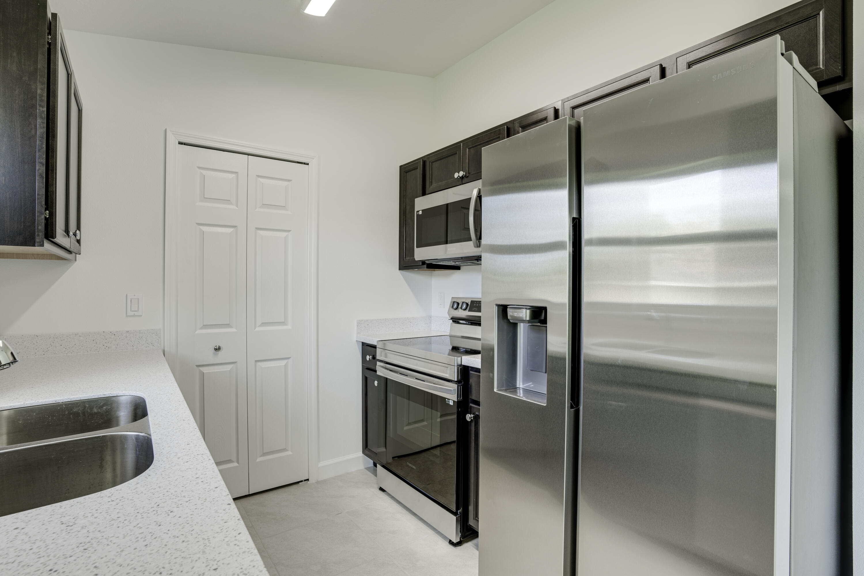 5264 Southeast 43rd Street Okeechobee, FL 34974 - Photo 8 of 16 a kitchen with a refrigerator and a sink