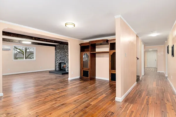 a view of a hallway with wooden floor and living room