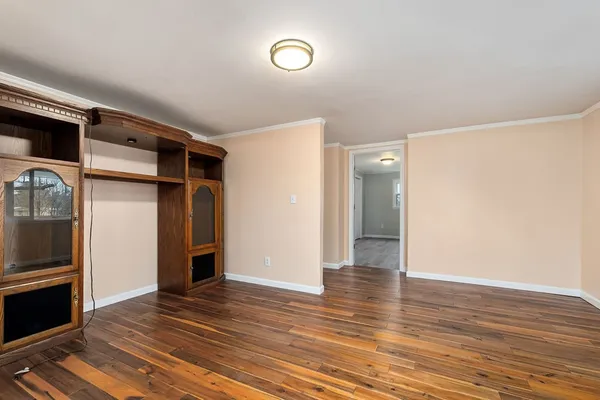 a view of an empty room with wooden floor