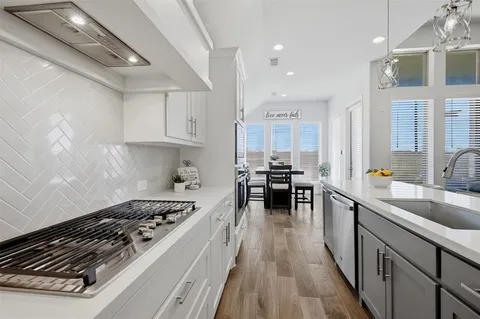 a kitchen with sink stove and cabinets