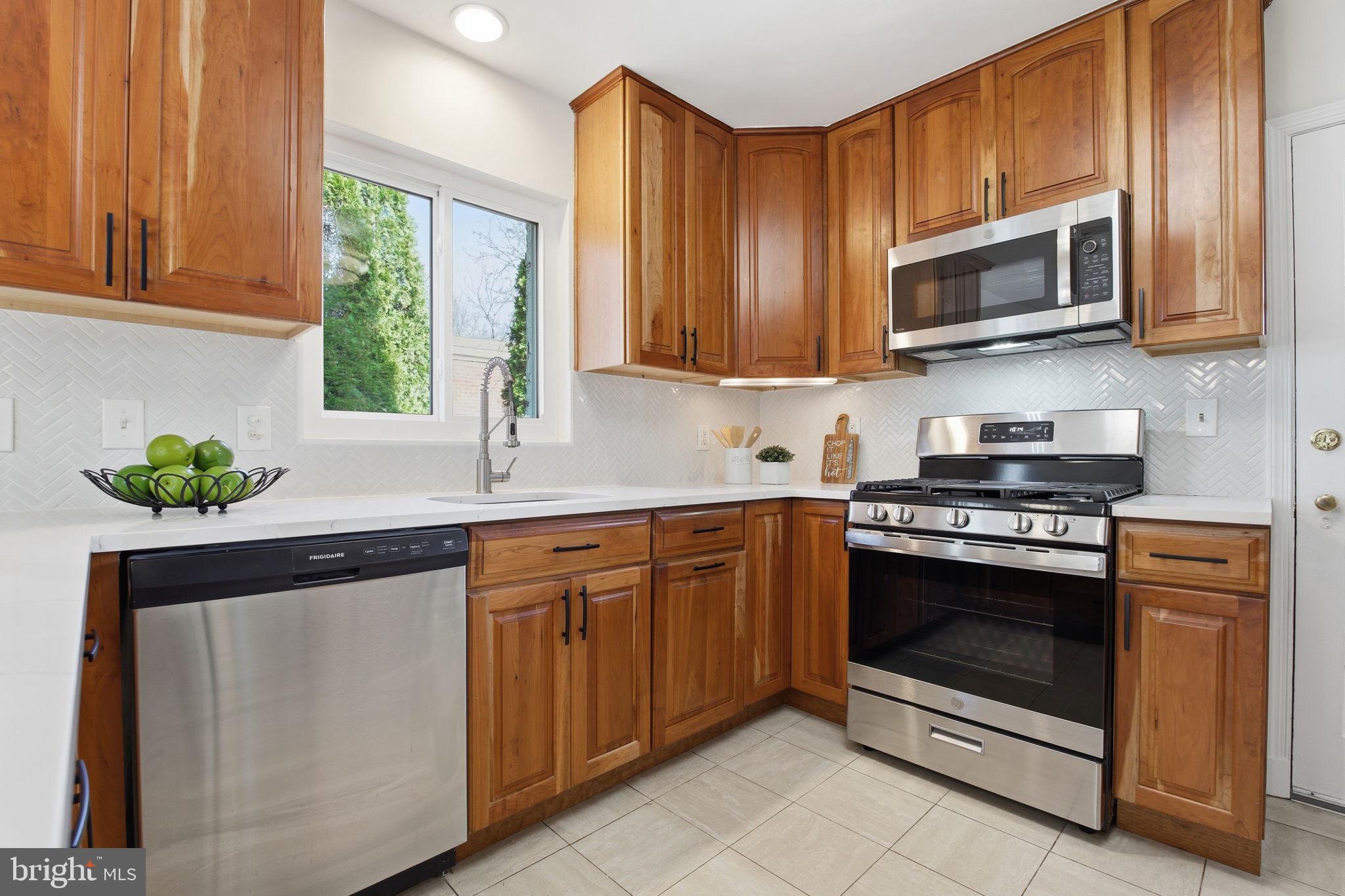 11527 Grandview Avenue Silver Spring, MD 20902 - Photo 8 of 36 a kitchen with stainless steel appliances granite countertop a stove a sink and a microwave