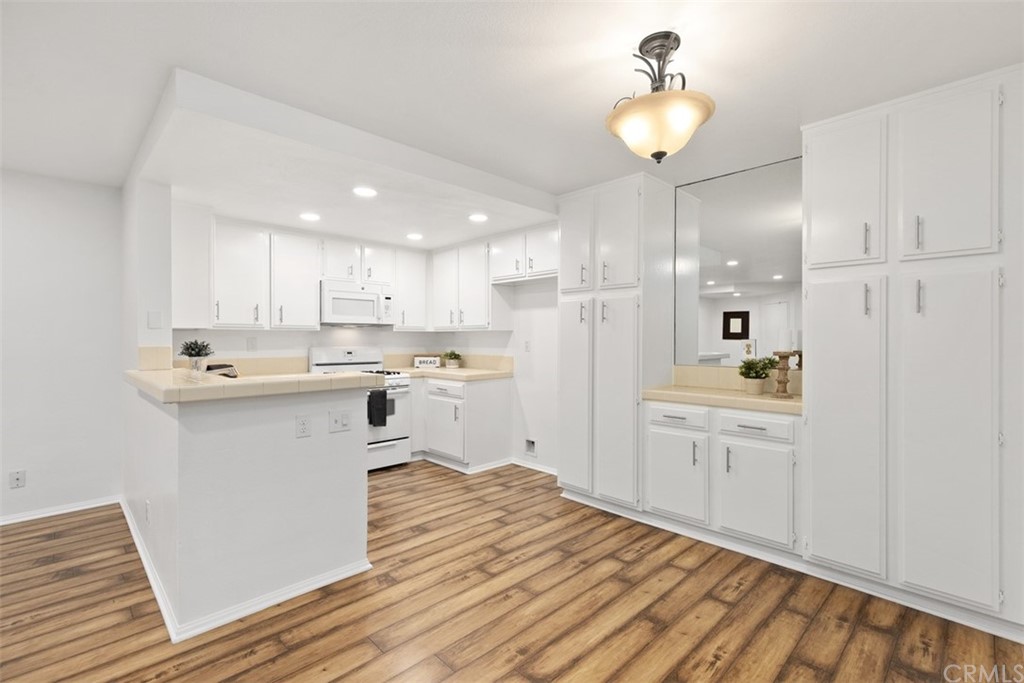 a kitchen with kitchen island white cabinets stainless steel appliances and wooden floor