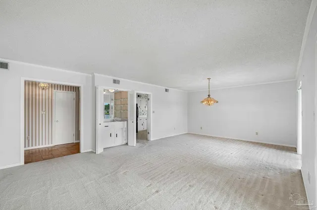 a view of an empty room with glass door and windows