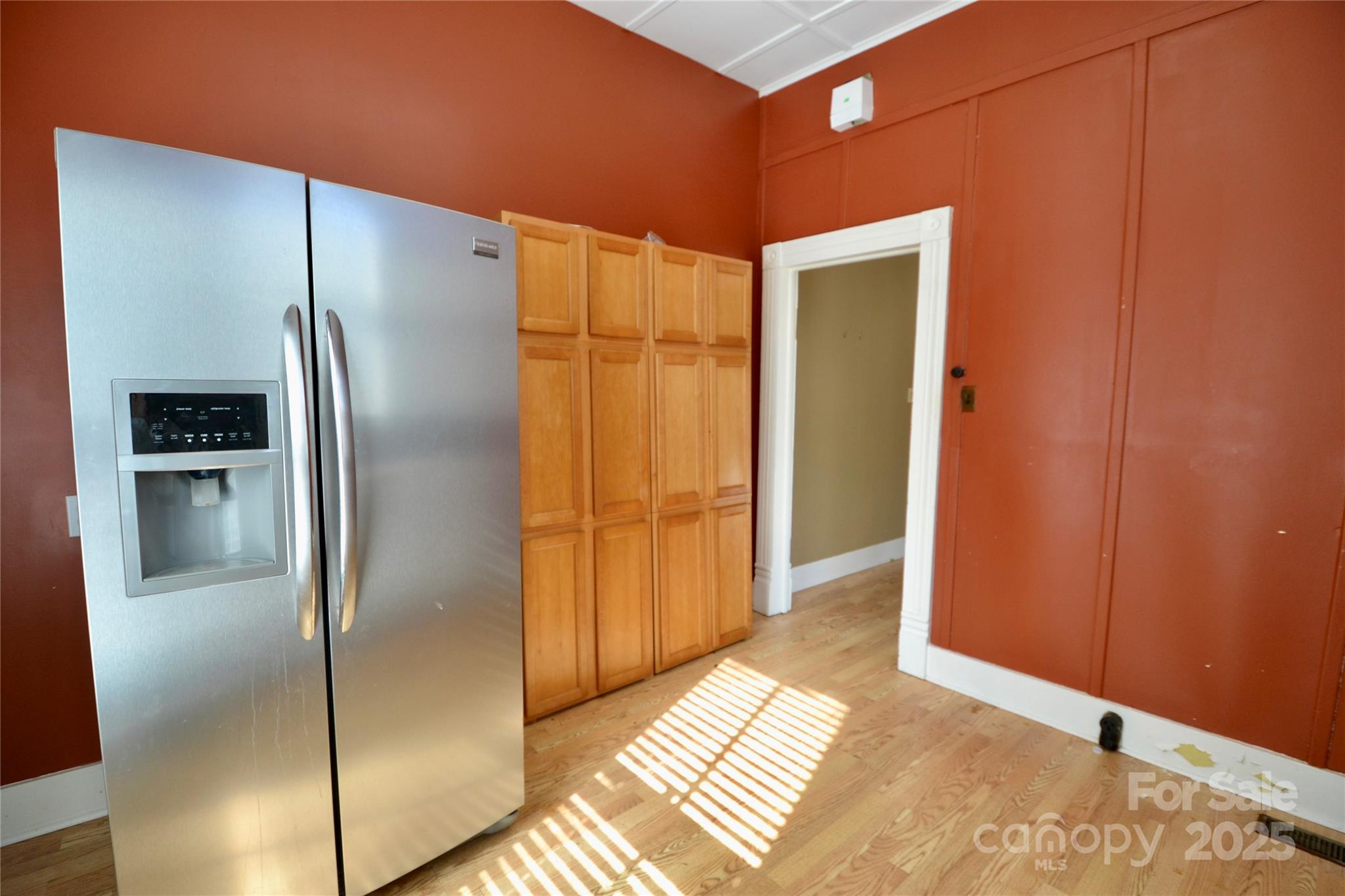 512 2nd Street Spencer, NC 28159 - Photo 26 of 33 a view of a refrigerator in kitchen and an empty room with wooden floor