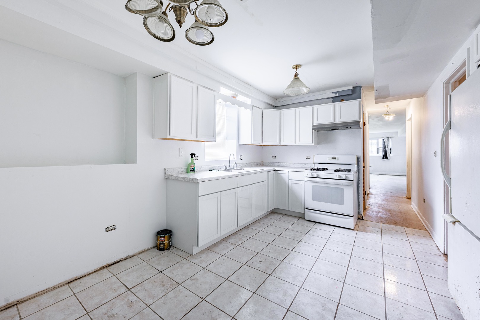 98 West 154th Street Harvey, IL 60426 - Photo 5 of 8 a kitchen with a refrigerator a sink and a stove top oven