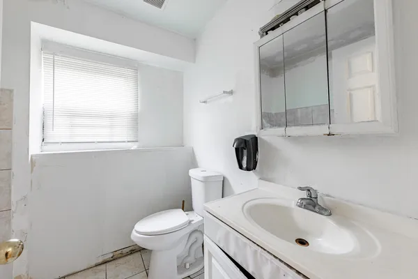a bathroom with a sink toilet and a mirror