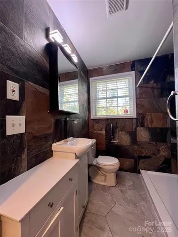 a bathroom with a sink a toilet and mirror
