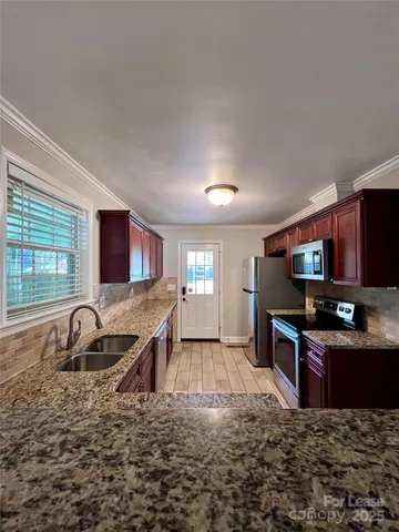 a kitchen with stainless steel appliances granite countertop a sink stove and cabinets