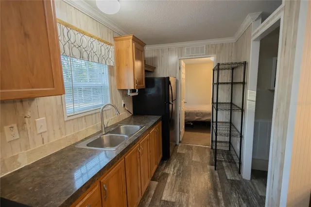 a bedroom with a bed and a flat tv screen on dresser