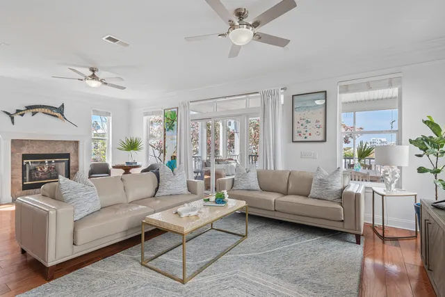 a living room with stainless steel appliances granite countertop furniture a stove a kitchen island with large windows and wooden floor