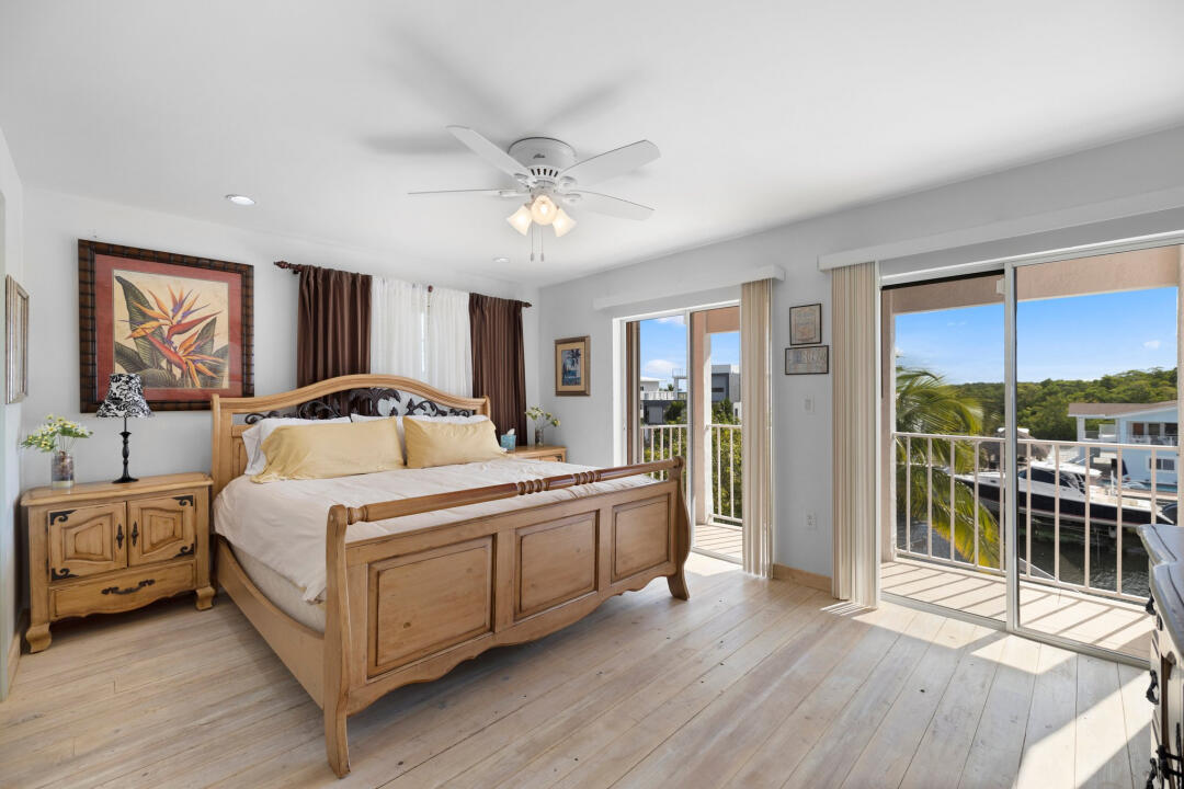 23 South Exuma Road Key Largo, FL 33037 - Photo 13 of 24 a bedroom with a large bed and a chandelier