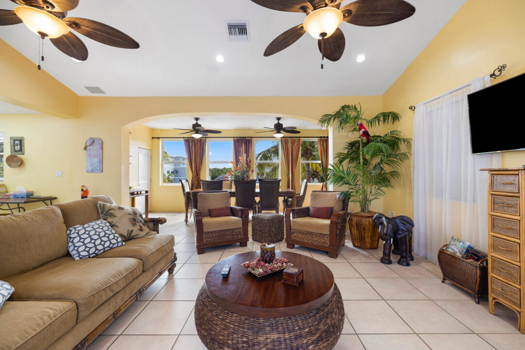 23 South Exuma Road Key Largo, FL 33037 - Photo 9 of 24 a living room with furniture a flat screen tv and a chandelier