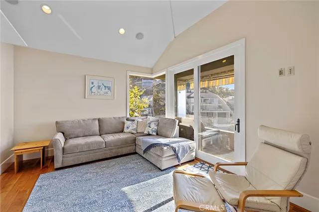 a living room with furniture and a dining table next to a window