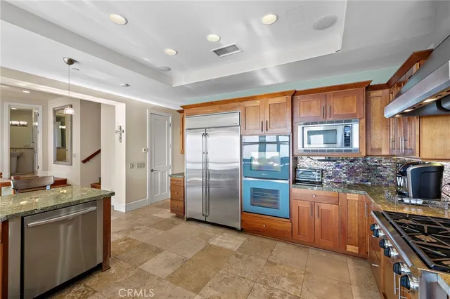 a kitchen with stainless steel appliances granite countertop a stove refrigerator and a sink