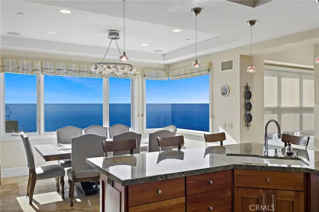 a very nice looking kitchen with granite countertop a stove two sinks and a island next to a large window