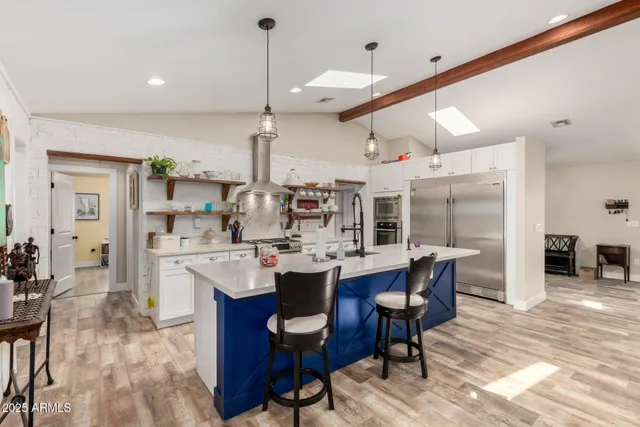 a kitchen with stainless steel appliances granite countertop a sink and a refrigerator