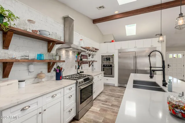 a kitchen with stainless steel appliances granite countertop a sink stove and refrigerator