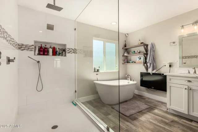 a bedroom with a bed and a flat tv screen on dresser