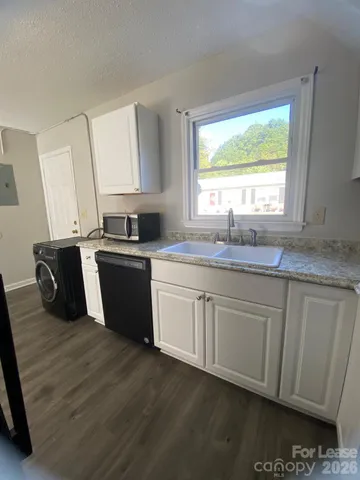 a kitchen with stainless steel appliances granite countertop a sink a stove a refrigerator a sink and dishwasher with wooden floor