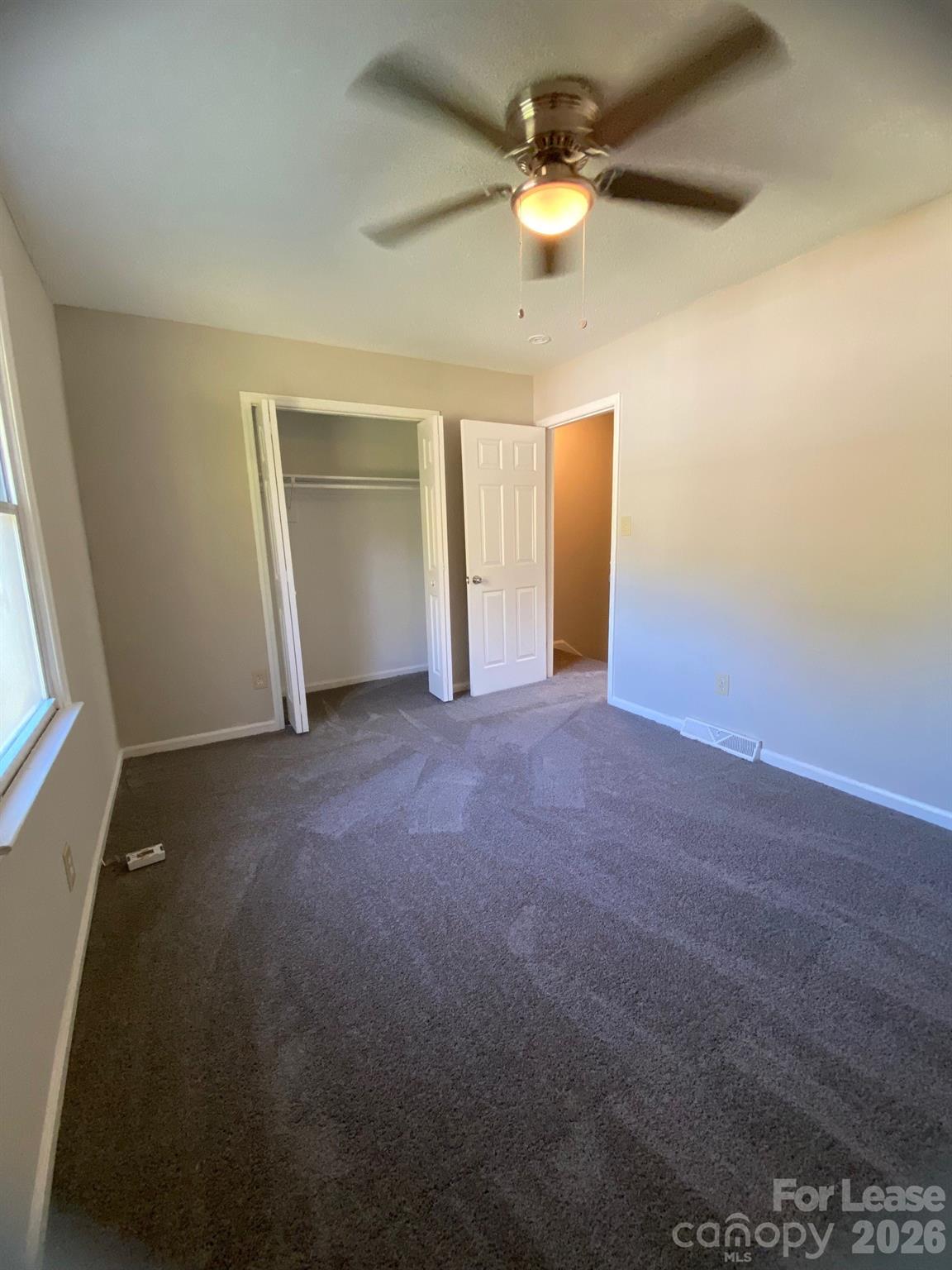900 Junius Street, Unit A Gastonia, NC 28052 - Photo 7 of 10 en empty room with windows and fan