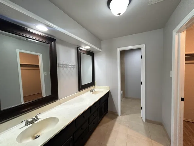a bathroom with a double vanity sink and a mirror