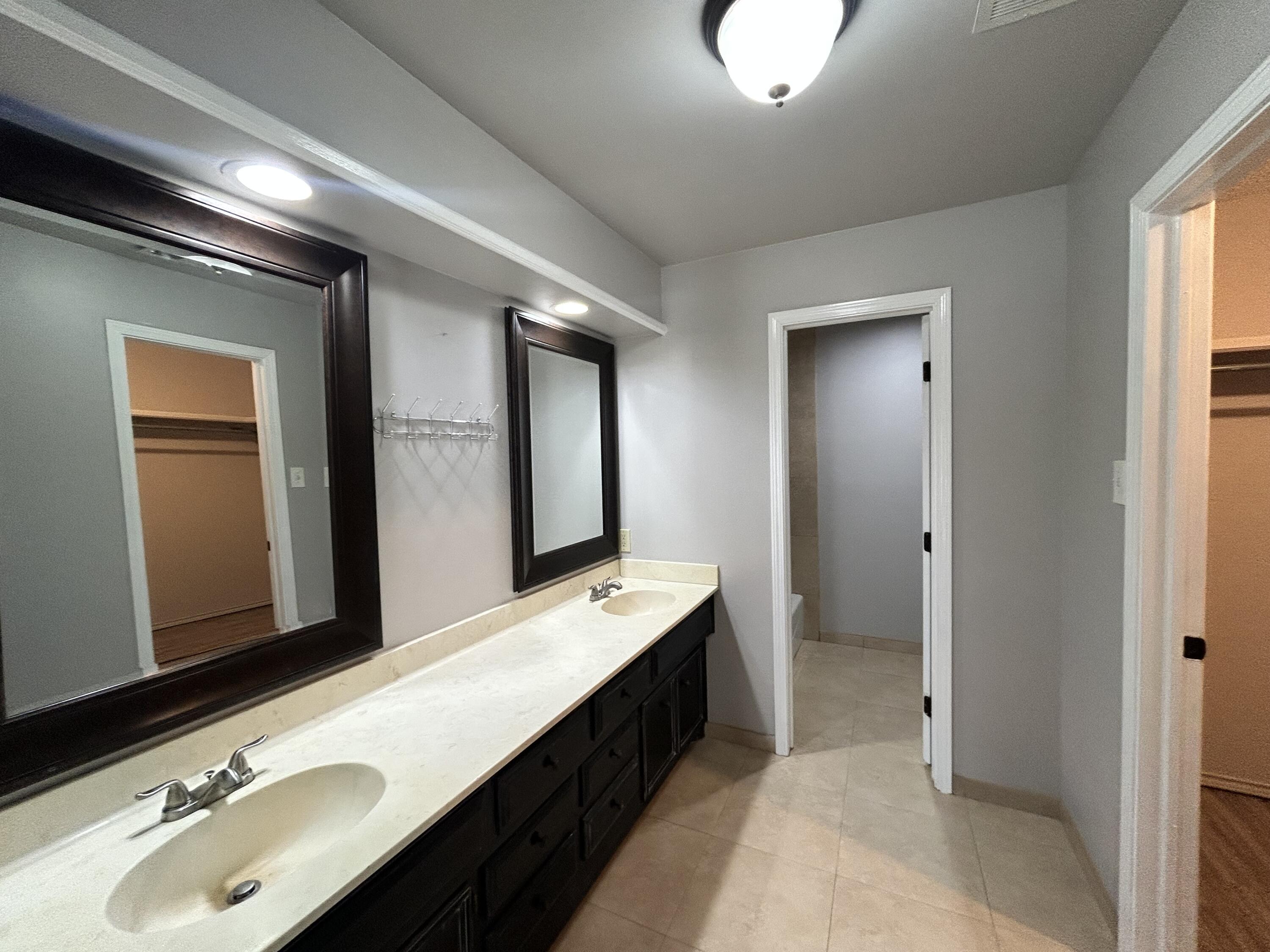 5517 89th Street Lubbock, TX 79424 - Photo 11 of 20 a bathroom with a double vanity sink and a mirror