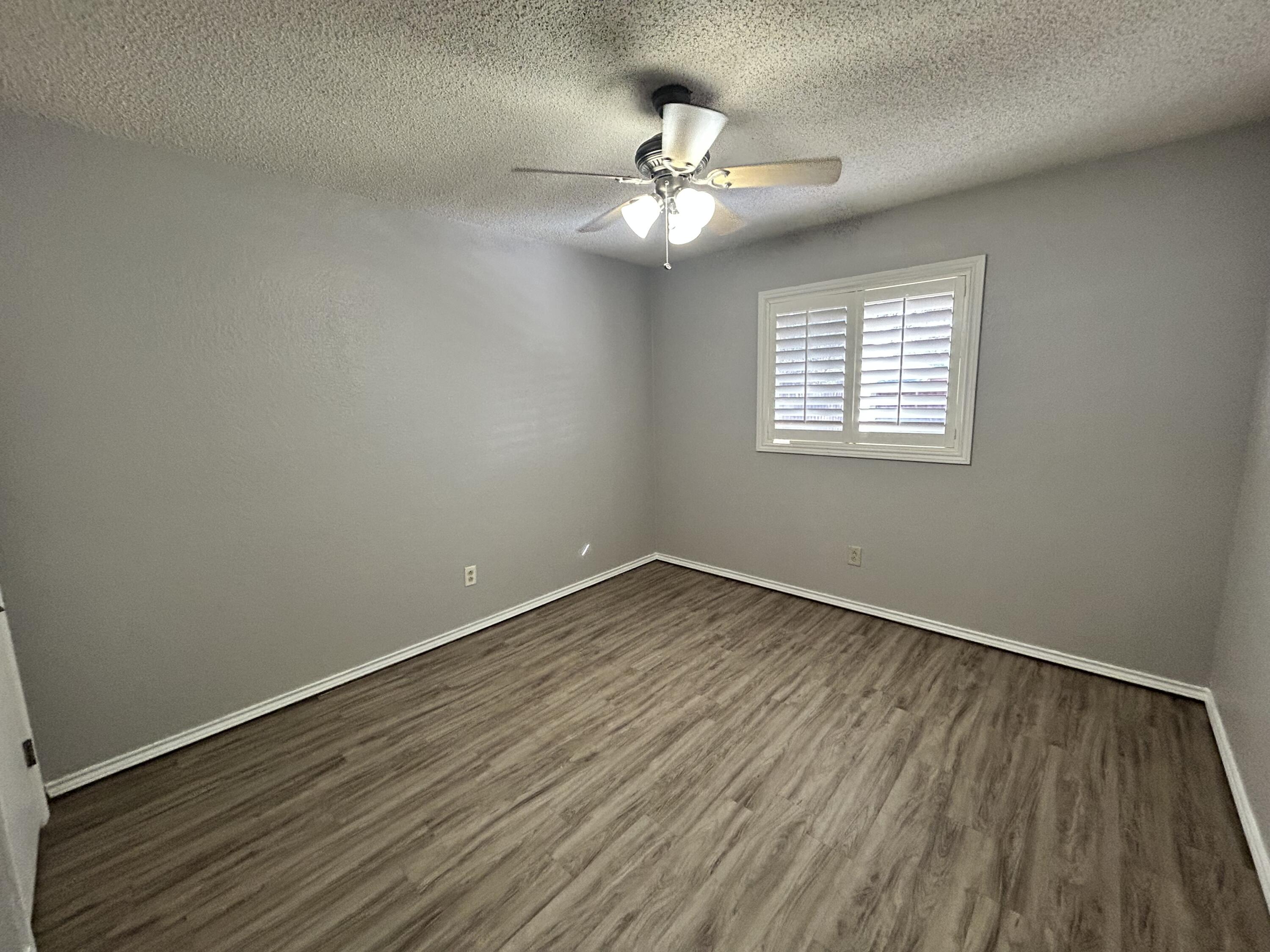 5517 89th Street Lubbock, TX 79424 - Photo 16 of 20 an empty room with wooden floor and windows