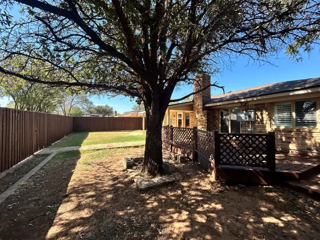 a view of a yard with wooden fence