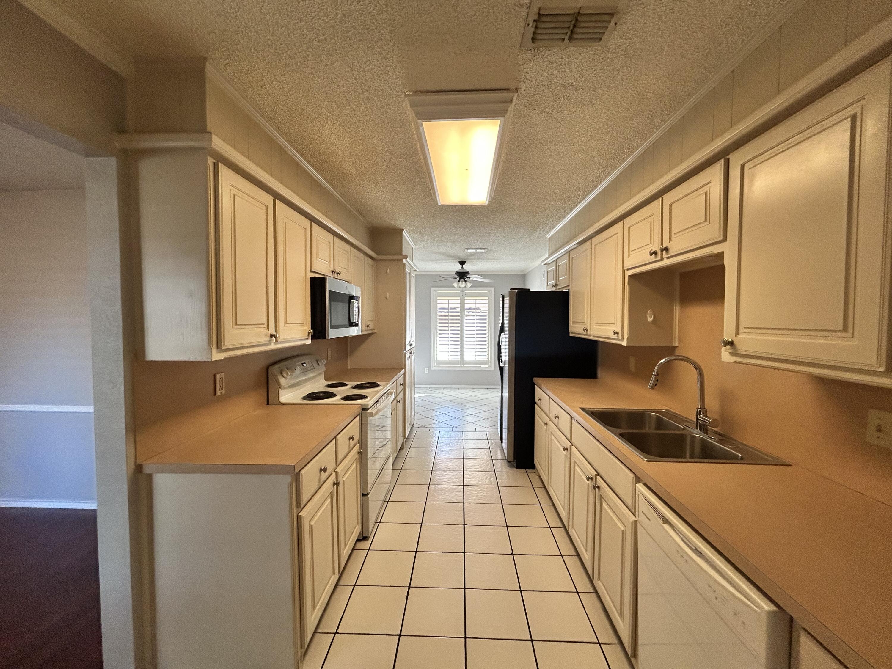 5517 89th Street Lubbock, TX 79424 - Photo 4 of 20 a kitchen with stainless steel appliances granite countertop a sink stove and refrigerator